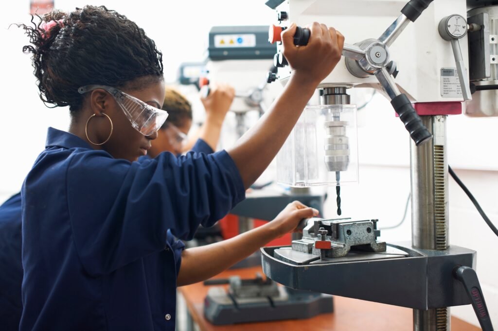 Students using drilling machines in college workshop